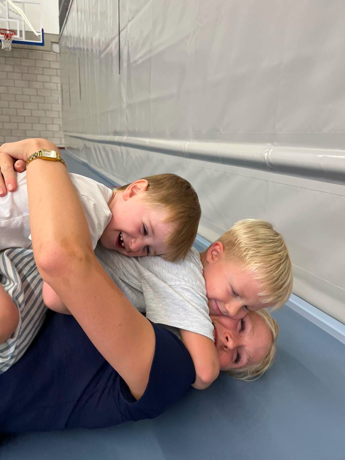 Twee kinderen stoeien lachend op een turnmat