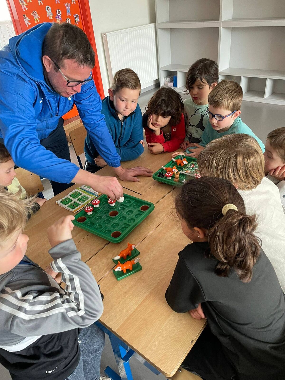 Kinderen spelen een gezelschapsspel met een begeleider