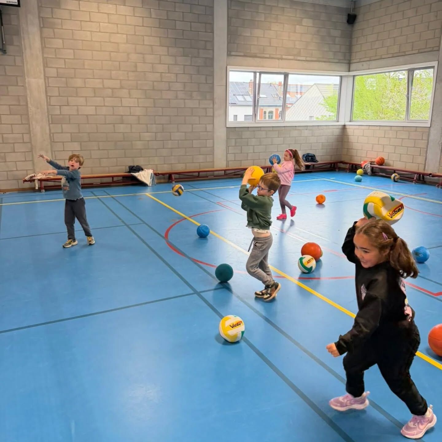 Kinderen spelen met ballen in de sporthal
