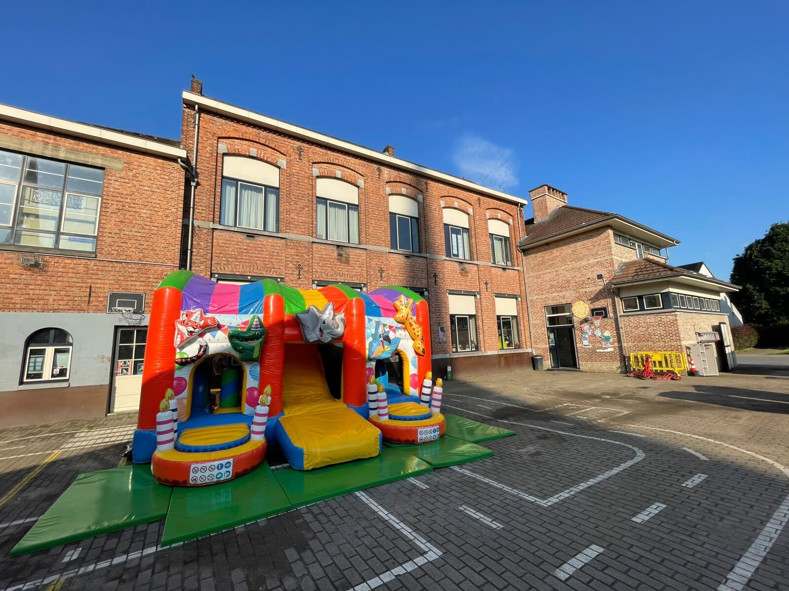 Kleurrijk springkasteel op de speelplaats van een school